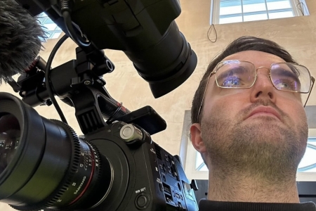 A selfie of Liam holding a camera on a shoot.