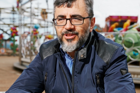 Alessandro Melis sitting in front of an amusement ride