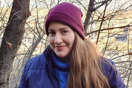 Catarina Mestre smiling at camera in maroon beanie outdoors in woodland