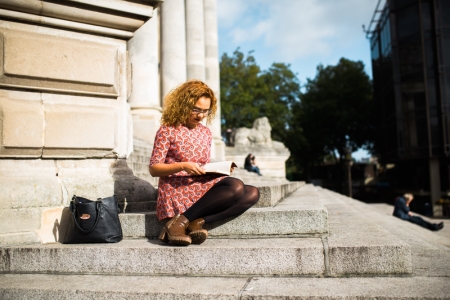 University of Portsmouth student reads a book on Portsmouth Guildhall steps