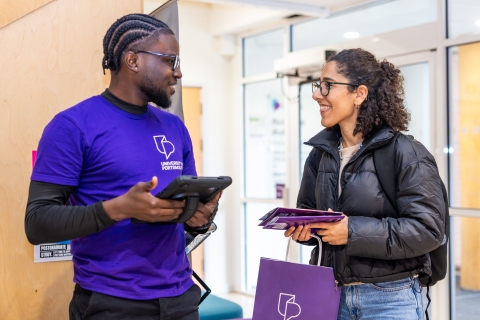 Member of staff offering information to a student at an Open Day