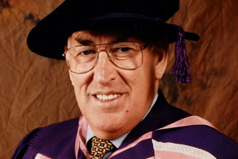 Sir Anthony Cleaver smiling at camera wearing graduation gown and cap