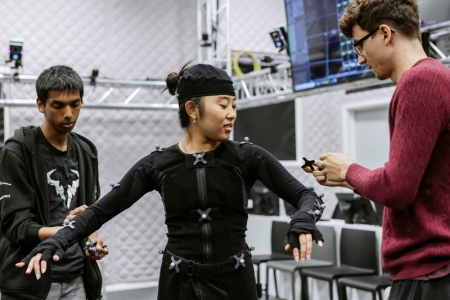 Staff member assisting student with motion capture suit.
B Roll Day 3